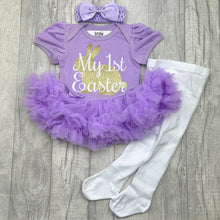 Load image into Gallery viewer, Baby girls short sleeve lilac tutu romper with bow headband above and white tights below. The tutu romper features a gold glitter cute bunny design with white script lettering over the top saying My 1st Easter.
