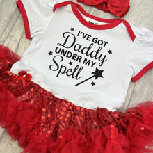 Load image into Gallery viewer, Baby girls white with red sequin tutu romper with matching bow headband above. The tutu romper features black glitter stars and wand design with lettering saying I've got Daddy under my spell.
