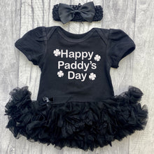 Load image into Gallery viewer, Baby Girls short sleeve black tutu romper with bow headband above. The tutu romper features white glitter four leaf clover design with lettering in the middle saying Happy Paddy's Day.