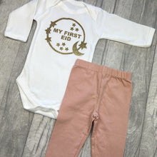 Load image into Gallery viewer, Long sleeve white romper and pink leggings. The romper features gold glitter moon and stars circle design with lettering in the middle saying My First Eid.