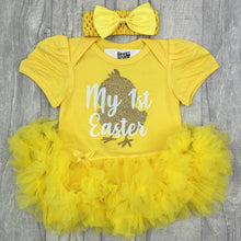Load image into Gallery viewer, Baby girls short sleeve yellow tutu romper with bow headband above. The tutu romper features a gold baby chick design with white lettering over the top saying My 1st Easter.
