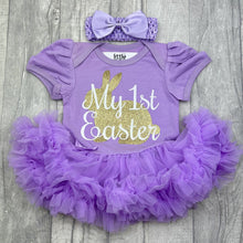 Load image into Gallery viewer, Baby girls short sleeve lilac tutu romper with bow headband above. The tutu romper features a cute gold bunny design with white script style lettering over the top saying My 1st Easter