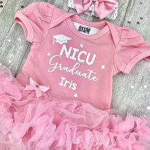 Load image into Gallery viewer, Baby girls short sleeve light pink tutu romper with bow headband above. The tutu romper features white glitter hat and stars design with lettering saying NICU Graduate, Personalised Name