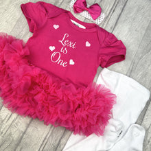 Load image into Gallery viewer, Dark pink short sleeve tutu romper with matching bow headband above and white tights to the right side. The tutu romper features white glitter love hearts design and lettering in the middle saying Personalised Name is One.