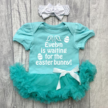 Load image into Gallery viewer, Baby girls short sleeve green tutu romper with bow headband above. The tutu romper features white glitter easter eggs design with lettering saying Personalised Name is waiting for the Easter Bunny!