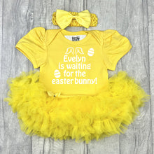 Load image into Gallery viewer, Baby girls short sleeve yellow tutu romper with bow headband above. The tutu romper features white glitter easter eggs design with lettering saying Personalised Name is waiting for the Easter Bunny!
