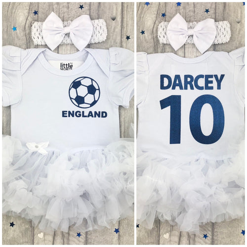 Baby Girl White tutu romper dress, featuring england the three lions football on the front and personalised Name and number on the back in navy blue, including a matching headband