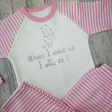 Load image into Gallery viewer, Pink and White striped girls pyjama set. The top features a silver glitter Winnie the Pooh design with lettering underneath saying When I wake up I will be 1.