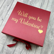 Load image into Gallery viewer, Red large square gift box with ribbon tie. The box features gold love heart design with script lettering saying Will you be my Valentine?