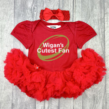 Load image into Gallery viewer, Baby girls short sleeve red tutu romper with bow headband above. The tutu romper features a sparkly gold glitter rugby ball design and white glitter text central over the top saying Wigan's Cutes Fan.