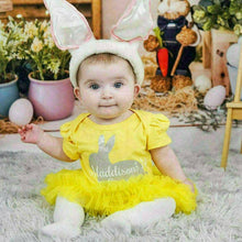 Load image into Gallery viewer, Baby model wearing yellow tutu romper. The tutu romper features a silver bunny design with white lettering over the top saying Name's 1st Easter