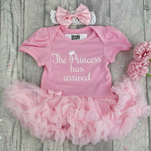Load image into Gallery viewer, Baby girls short sleeve light pink tutu romper with bow headband. The tutu romper features white glitter script lettering saying The Princess has arrived.