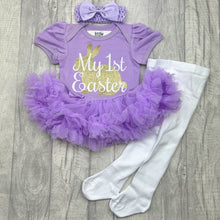 Load image into Gallery viewer, Baby girls short sleeve lilac tutu romper with bow headband above and white tights below. The tutu romper features a gold glitter cute bunny design with white script lettering over the top saying My 1st Easter.
