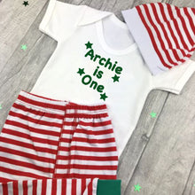 Load image into Gallery viewer, White short sleeve romper with green star design and text on. Red and white striped pants and hat.
