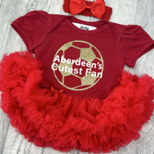 Load image into Gallery viewer, Baby girls red short sleeve tutu romper with bow headband above. The tutu romper features gold glitter football design and white text central over the top saying Aberdeen&#39;s Cutest Fan.
