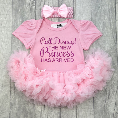 Baby girls light pink tutu romper with matching bow headband above. The tutu romper features dark pink glitter  lettering saying Call Disney! The new princess has arrived