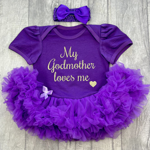 Baby girls dark purple tutu romper with matching bow headband above. The tutu romper features gold script lettering saying My Godmother loves me.