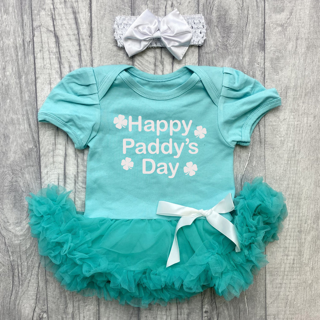 Baby Girls short sleeve green tutu romper with bow headband above. The tutu romper features white glitter four leaf clover design with lettering in the middle saying Happy Paddy's Day.