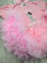 Load image into Gallery viewer, A baby girl's pink short-sleeve bodysuit with a matching ruffled tutu skirt and bow. The bodysuit is personalized with the text 'Lydia's 1st Birthday' and a glittery number 1 graphic.
