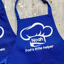 Load image into Gallery viewer, Blue Kids Apron featuring a White Glitter Chef Hat design with Personalised Name in the middle and lettering saying Dad&#39;s little helper underneath
