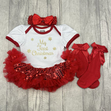 Load image into Gallery viewer, Baby girls short sleeve white with red sequin tutu romper and matching bow headband above and knee high socks to the side. The tutu romper features gold glitter snowflakes design with lettering in the middle saying My First Christmas
