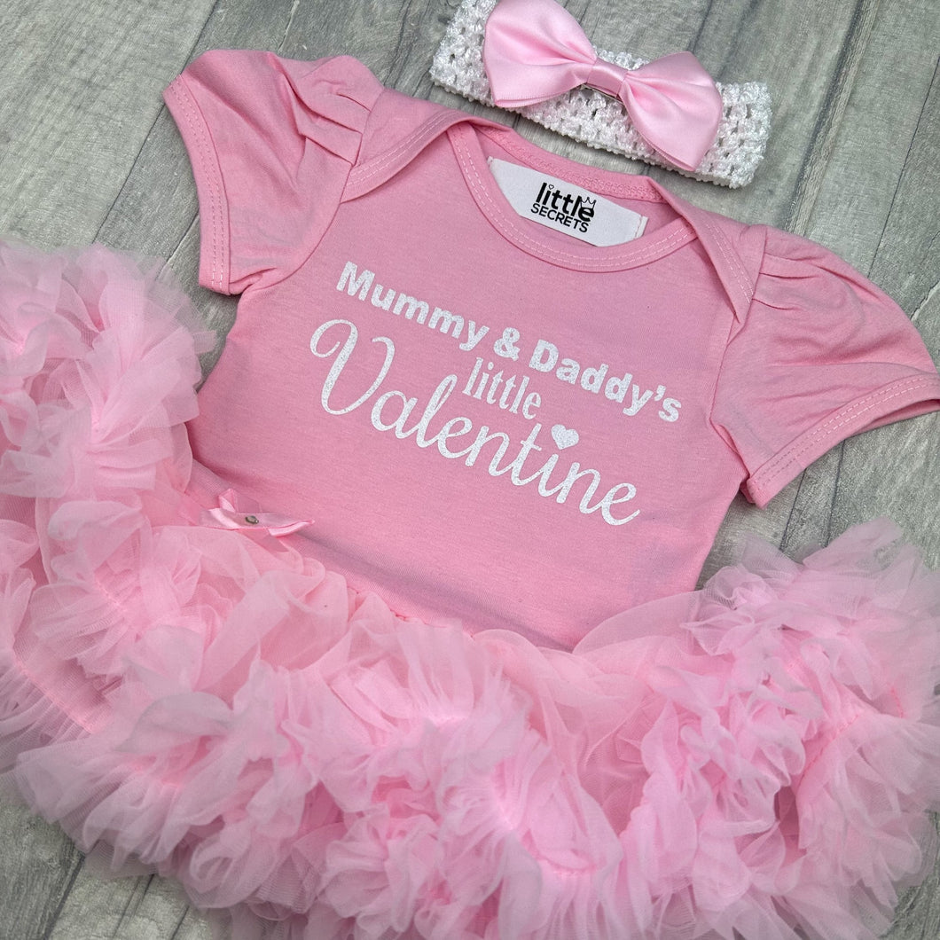 Baby girls short sleeve light pink tutu romper with bow headband above. The tutu romper features white glitter lettering saying Mummy & Daddy's little Valentine