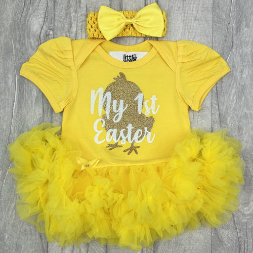 Baby girls short sleeve yellow tutu romper with bow headband above. The tutu romper features a gold baby chick design with white lettering over the top saying My 1st Easter.