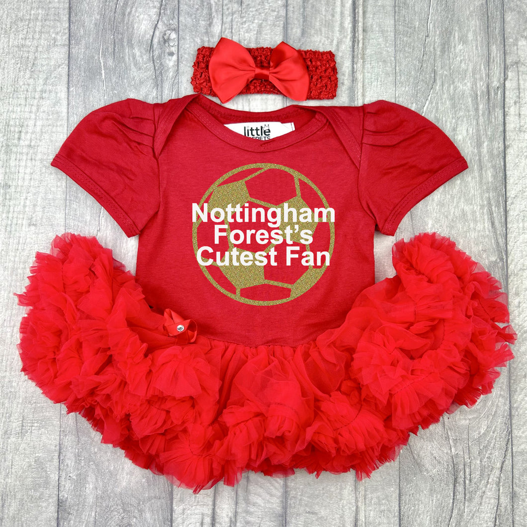Baby girls short sleeve red tutu romper with bow headband above. The tutu romper features a gold glitter football design with white lettering central over the top saying Nottingham Forest's Cutest Fan.