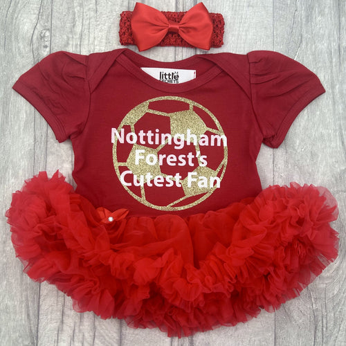 Baby girls short sleeve red tutu romper with bow headband above. The tutu romper features a gold football design with white lettering central over the top saying Nottingham Forest's Cutest Fan.