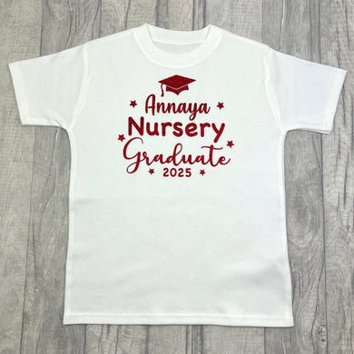 Children's white t-shirt featuring red stars and graduation cap design with lettering saying Personalised name Nursery Graduate 2025.