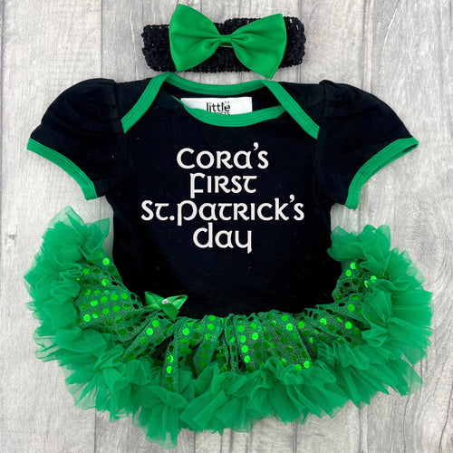 Baby Girls black and green sequin tutu romper with bow headband above. The tutu romper features white glitter lettering saying Personalised Name First St Patrick's Day.