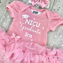 Load image into Gallery viewer, Baby girls short sleeve light pink tutu romper with bow headband above. The tutu romper features white glitter hat and stars design with lettering saying NICU Graduate, Personalised Name
