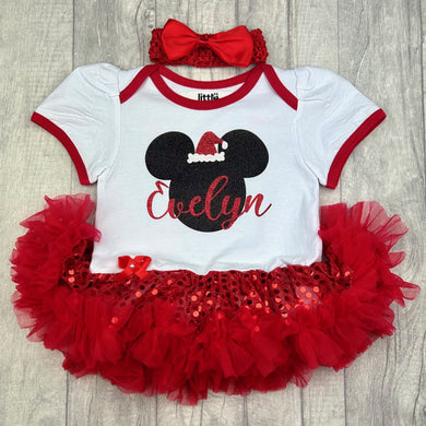 Baby girls white with red sequin tutu romper and matching bow headband above. The tutu romper features black glitter mickey mouse design with santa hat on. Personalised red glitter name.