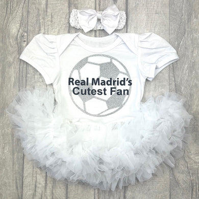 Baby outfit with 'Real Madrid's Cutest Fan' text and football design on a white tutu romper. Matching headband above.