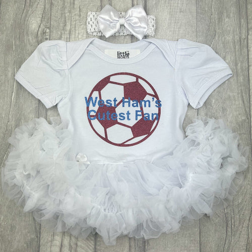 Baby girls short sleeve white tutu romper with bow headband above. The tutu romper features a maroon football design with blue lettering central over the top saying West Ham's Cutest Fan.